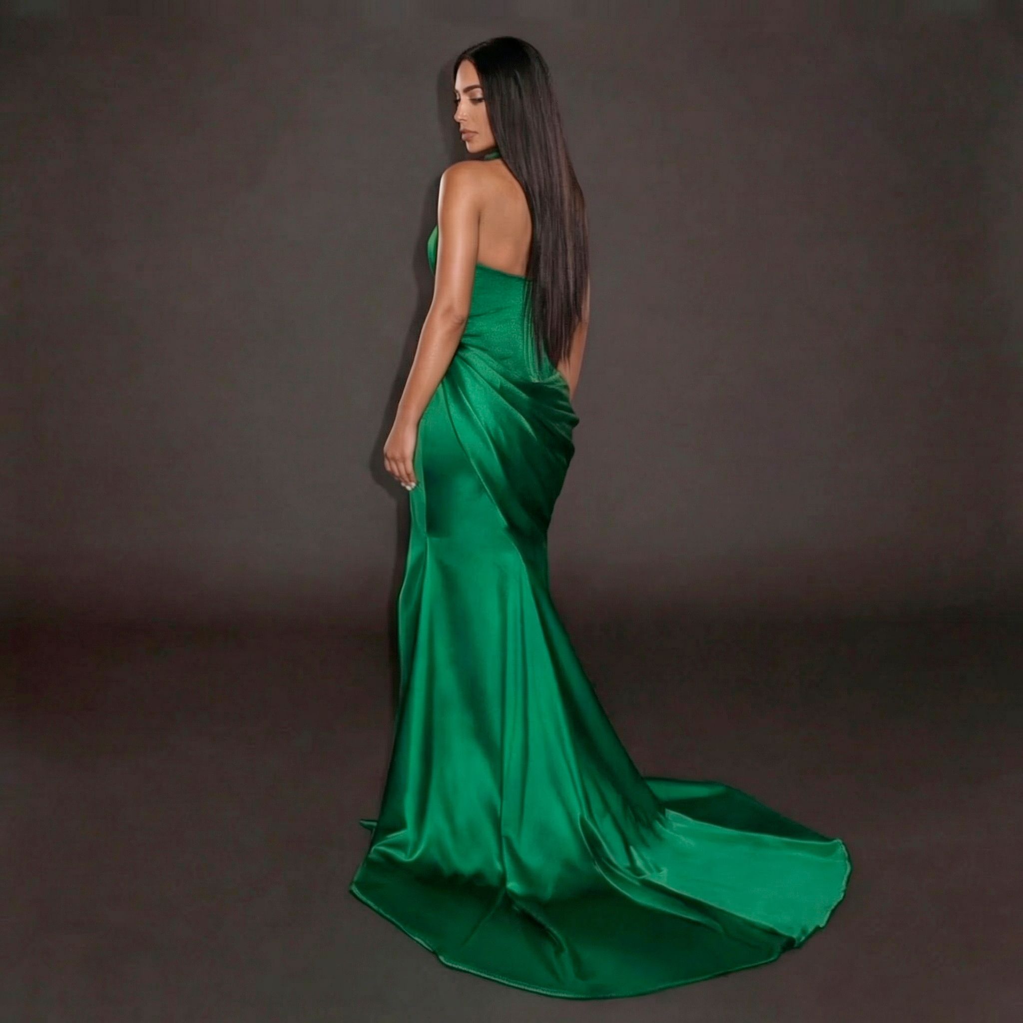Woman wearing a green evening gown against a dark background
