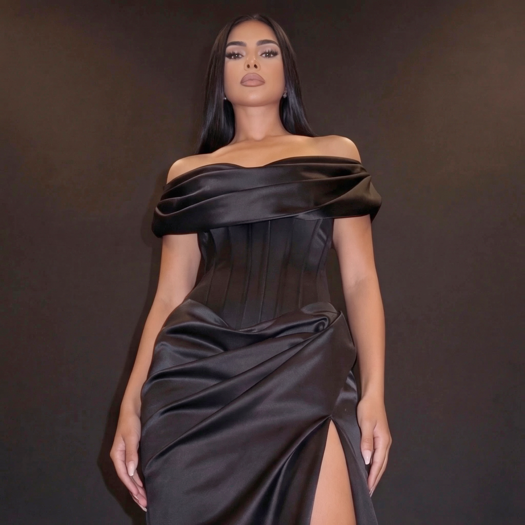 Woman wearing a black off-shoulder dress against a dark background