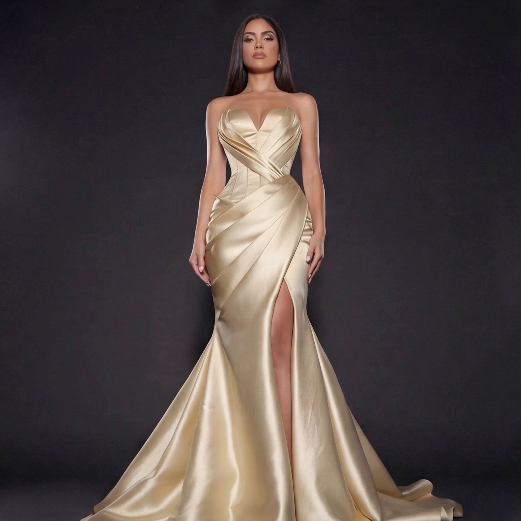 Woman wearing a gold evening gown against a dark background
