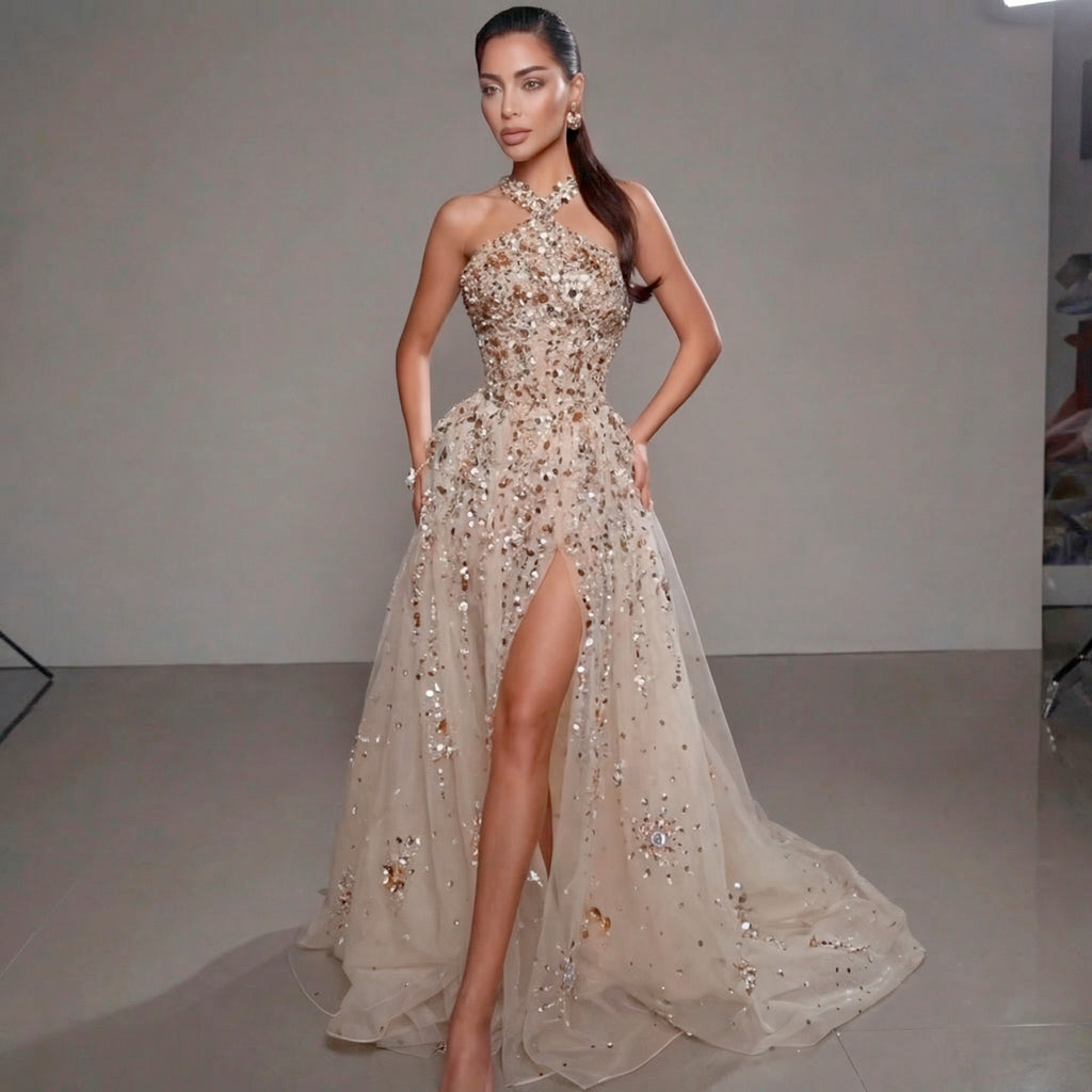 Woman in a sparkling evening gown with a high slit on a plain background