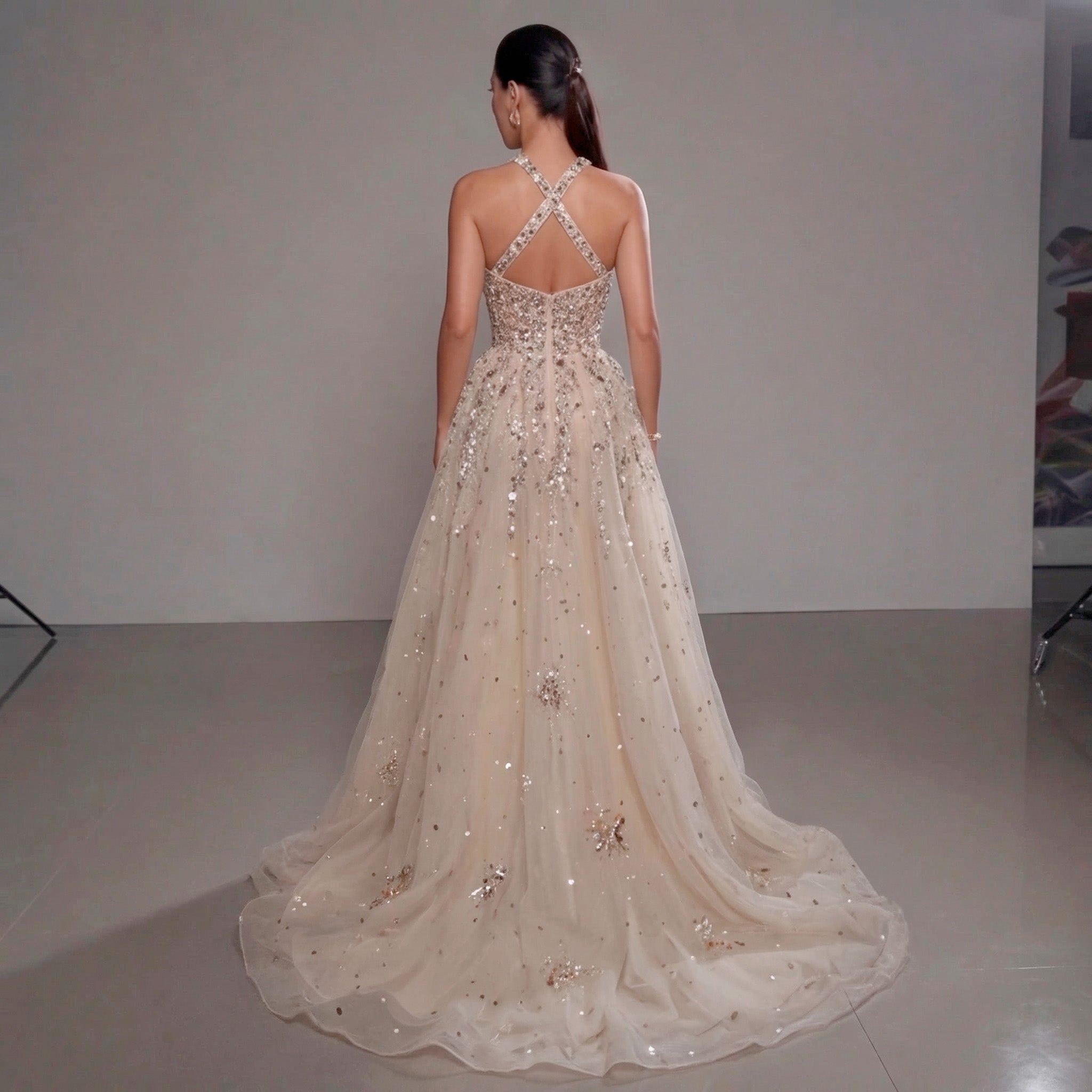 Woman wearing a sparkling evening gown with a plain background