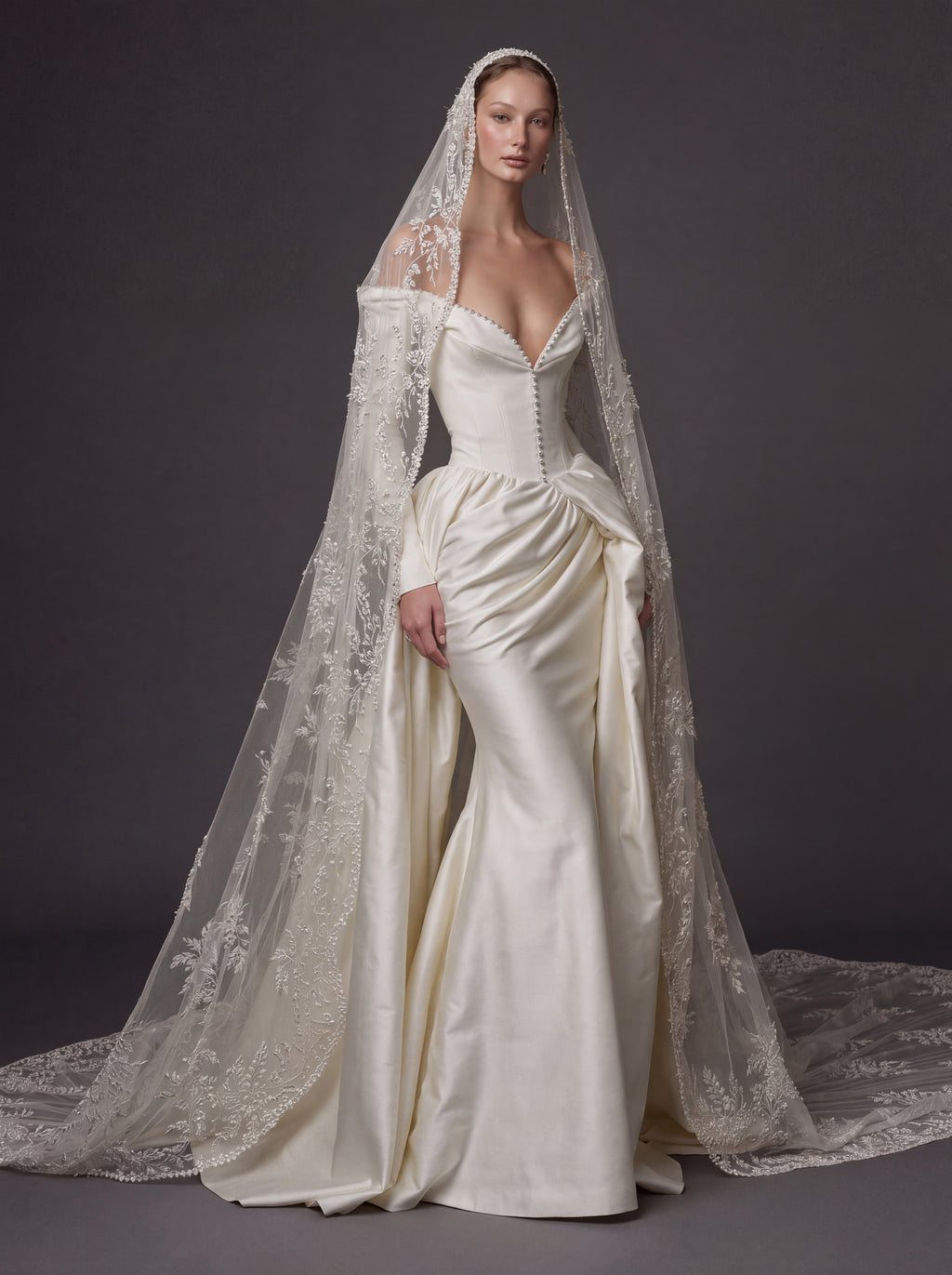 Pearl White Satin Corset Wedding Gown – Plunging Sweetheart Neckline, Draped Overskirt, Long Sleeves & Embroidered Cathedral Veil
