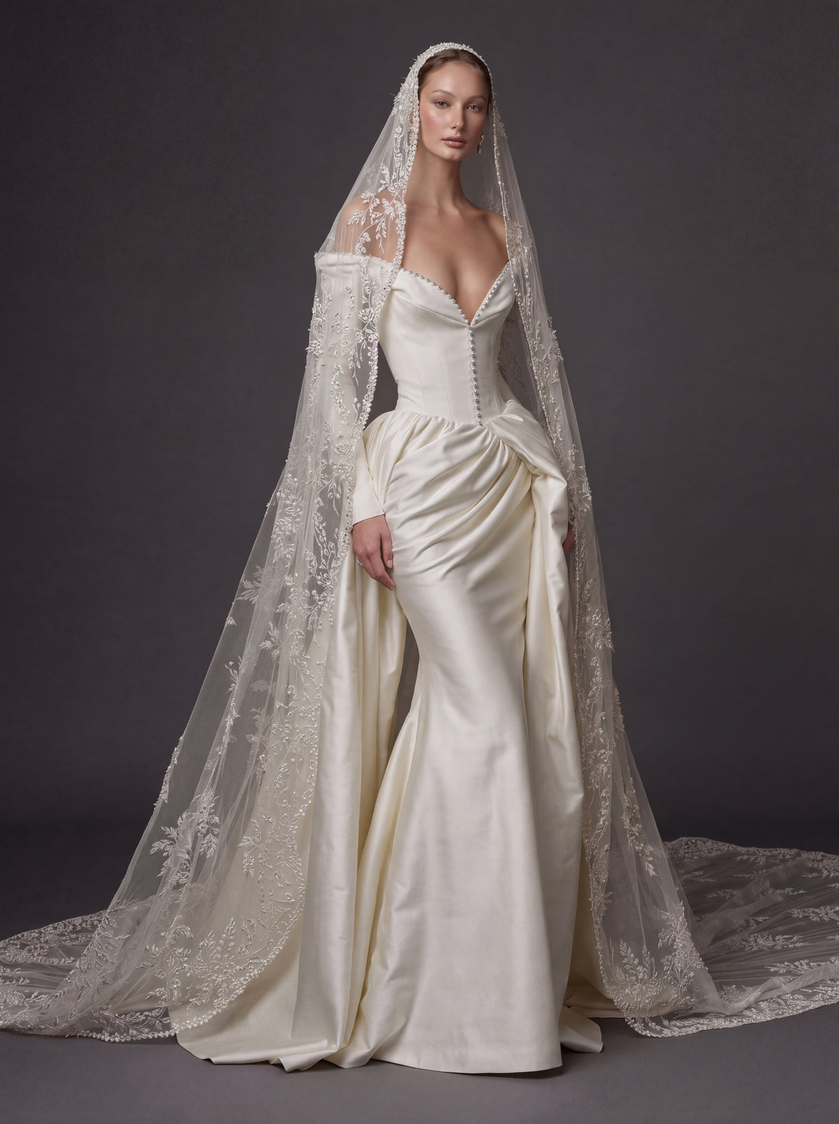 Pearl White Satin Corset Wedding Gown – Plunging Sweetheart Neckline, Draped Overskirt, Long Sleeves & Embroidered Cathedral Veil
