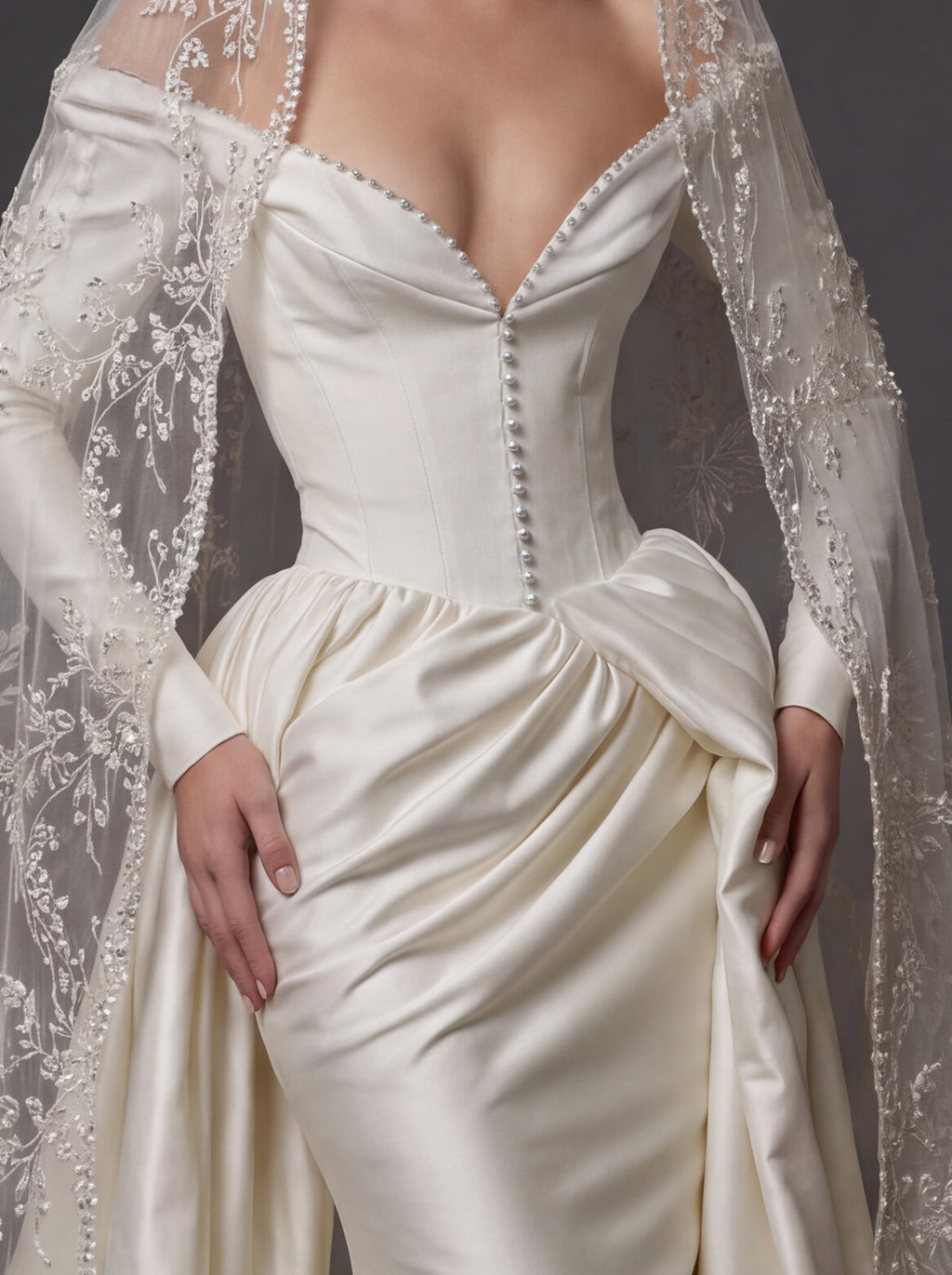 Pearl White Satin Corset Wedding Gown – Plunging Sweetheart Neckline, Draped Overskirt, Long Sleeves & Embroidered Cathedral Veil