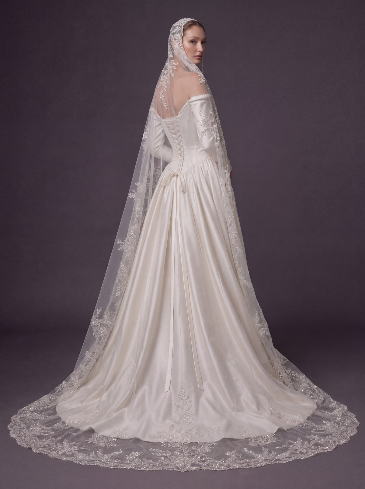 Pearl White Satin Corset Wedding Gown – Plunging Sweetheart Neckline, Draped Overskirt, Long Sleeves & Embroidered Cathedral Veil